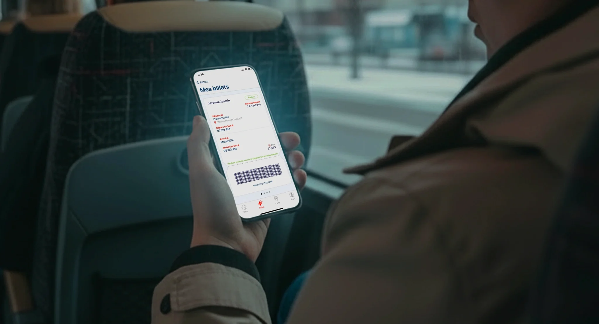 Passenger viewing a mobile ticket with QR code and travel details inside a bus using a transportation app