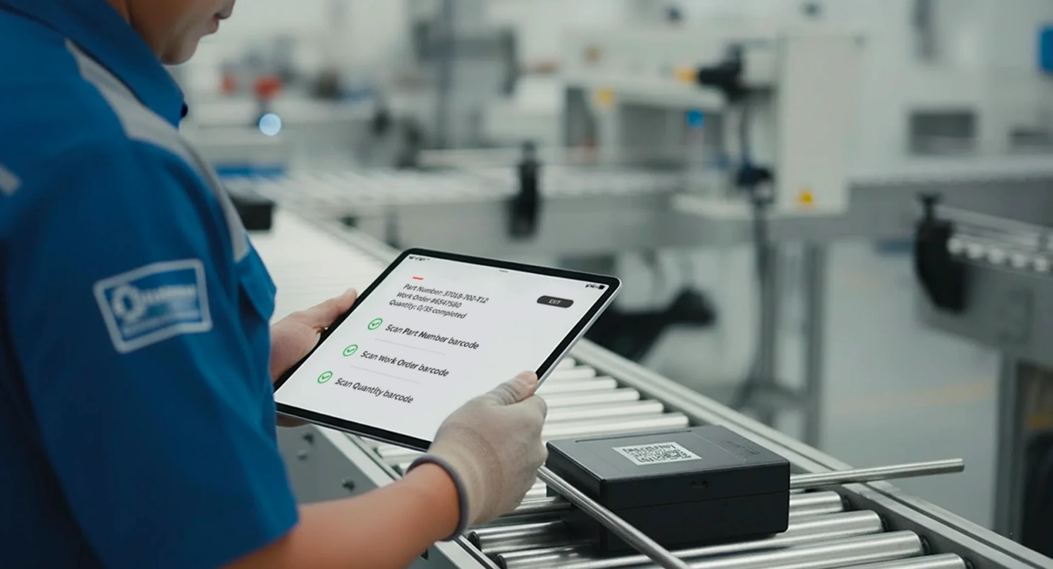 Warehouse worker using a tablet to scan a package barcode and manage returns through a logistics mobile app