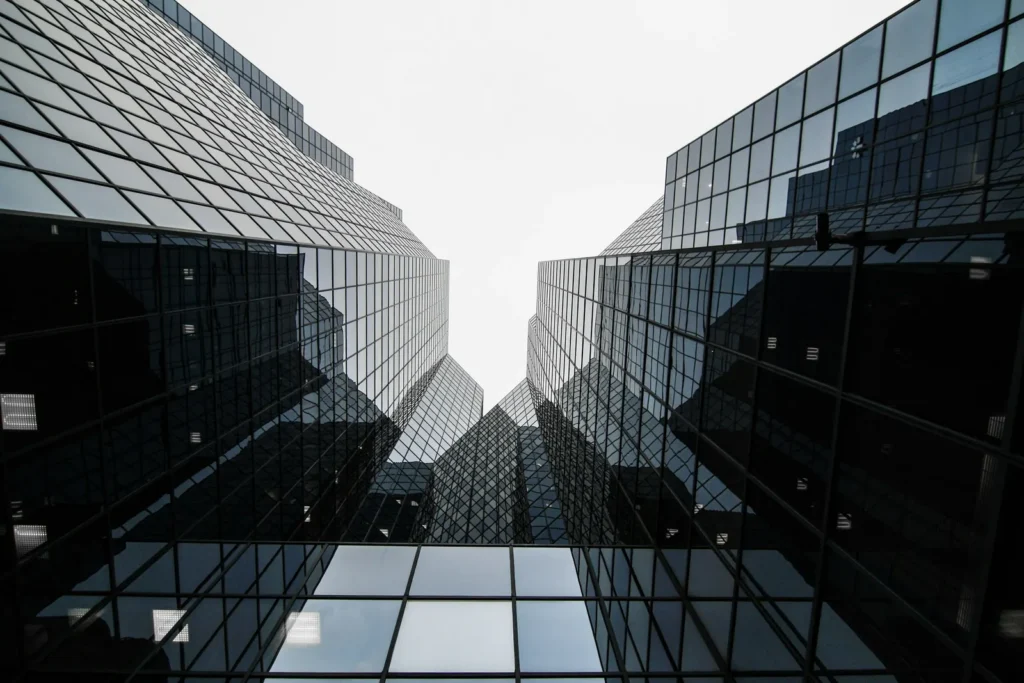 Low-angle view of glass skyscrapers whose grid facades evoke the interconnected nodes of a Bluetooth mesh network