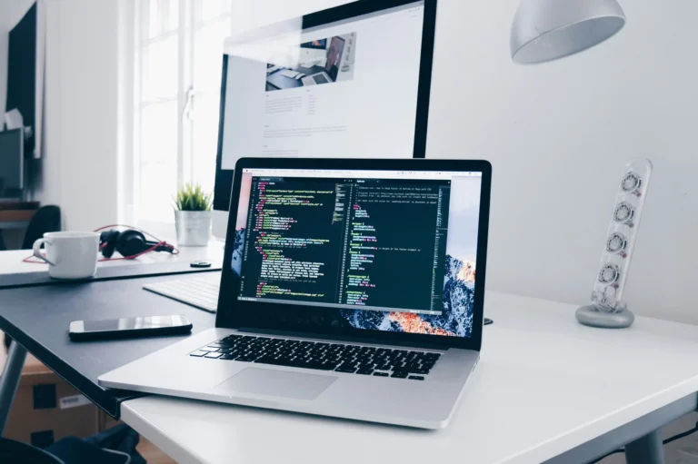 Laptop displaying code on a desk, representing AI code vulnerabilities in a generated app