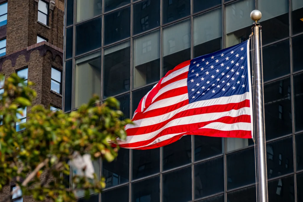 American flag near a building and a tree